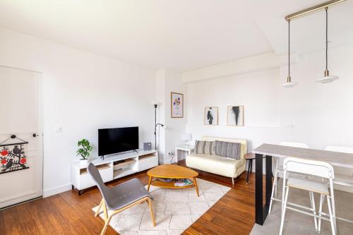 una sala de estar blanca con mesa y sillas en GuestReady - A minimalist comfort in Vanves, en Vanves