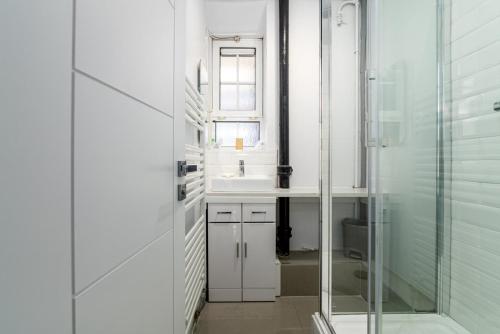 a bathroom with a sink and a glass shower at GuestReady - A British charm in South Bank in London