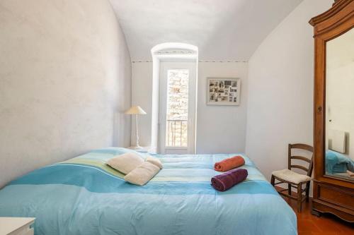 Un dormitorio con una cama azul con almohadas. en La Maison de B, en Lumio