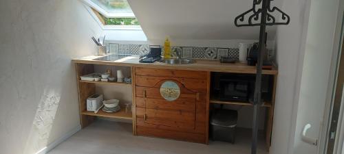 une petite cuisine avec un évier et un comptoir dans l'établissement La chambre de la maison du four à pain, à Grandchamp