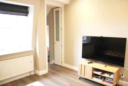 a living room with a large flat screen tv at GuestReady - Quaint English Flat near Portobello in London