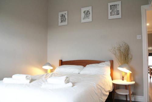 a bedroom with a large white bed with two lamps at GuestReady - Quaint English Flat near Portobello in London
