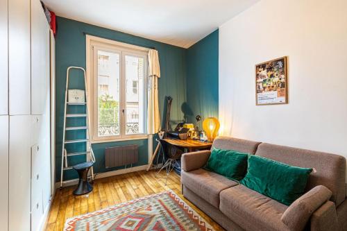 GuestReady - Charming Getaway with Terrace في باريس: غرفة معيشة مع أريكة ونافذة