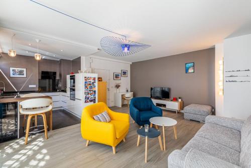 un salon avec un canapé et des chaises et une cuisine dans l'établissement GuestReady - Appartement Lumineux au 15ème, à Paris