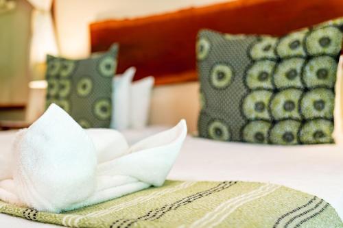 a close up of a bed with pillows on it at Bayete Guest Lodge in Victoria Falls