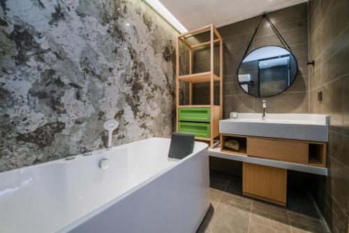 a bathroom with a tub and a sink and a mirror at Mehood Hotel Jining Zoucheng in Zoucheng