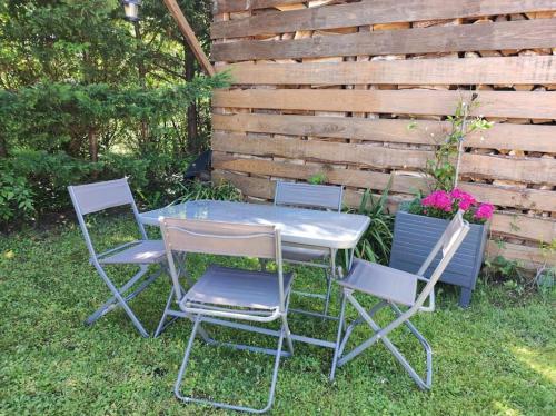 a table and four chairs in front of a fence at La Villa Pacha in Avallon