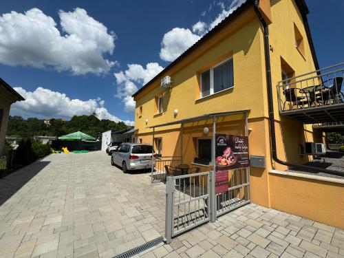 a yellow building with a car parked in front of it at Apartmány Hujer 2 in Bojnice
