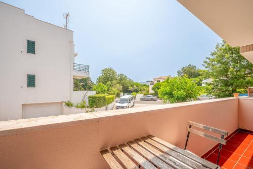 a bench on a balcony with a view of a street at GuestReady - Coastal Bliss in Praia de Troia in Troia