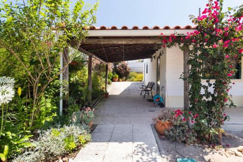 a garden corridor with flowers and plants at GuestReady - Carvalhal Residence near Pego Beach in Comporta