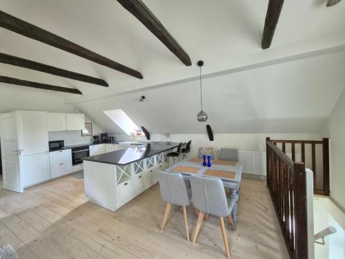 a kitchen with white cabinets and a table and chairs at Apartment in Danmark -Petersminde Exclusive Apartments in Otterup