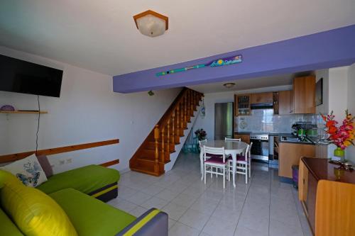 ein Wohnzimmer und eine Küche mit einem Sofa und einem Tisch in der Unterkunft Art House in Stara Baška