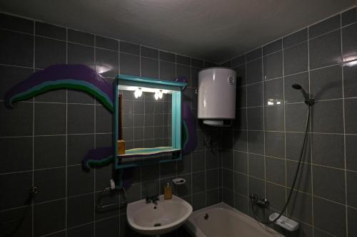 ein Bad mit einem Waschbecken und einem Spiegel in der Unterkunft Art House in Stara Baška