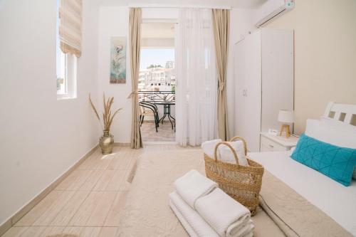 Habitación blanca con cama y comedor en Apartments Lungo Mare Ulcinj, en Ulcinj