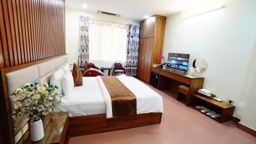 a bedroom with a bed and a desk and a television at Ho Sen Xanh Hotel in Hanoi