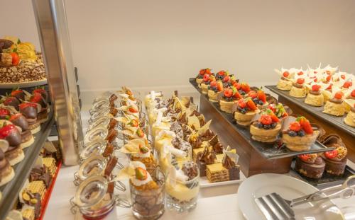 a display case with a bunch of desserts and pastries at TUI BLUE Makarska - Adults Only in Igrane