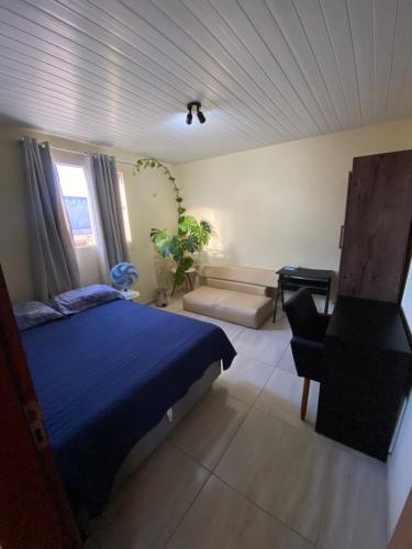 een slaapkamer met een blauw bed en een stoel bij Nosso lar em Natal - quarto in Natal