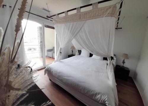 um quarto com uma cama de dossel branca em Cap Saint Martin Marina em Cap d'Agde