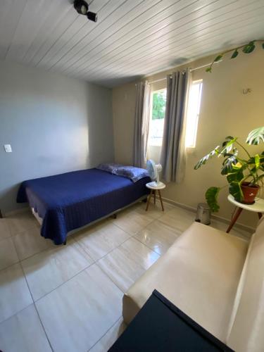 een slaapkamer met een blauw bed en een bank bij Nosso lar em Natal - quarto in Natal