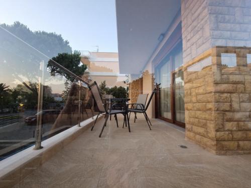a patio with chairs and a table on a balcony at Agora Luxury Villa I in Loutraki