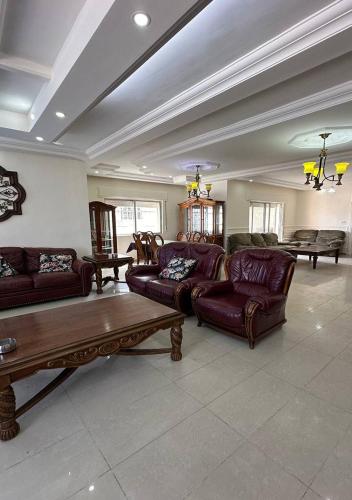 a large living room with couches and a table at Tlaa al ali amman 3 rooms furnished apartment المحكمة الدستورية in Umm Uthainah
