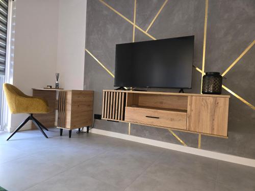 una sala de estar con TV en un centro de entretenimiento de madera en Kolo Apartament Gold en Kolo