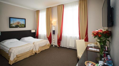 a hotel room with a bed and two windows at Optima Collection Kharkiv Hotel in Kharkiv