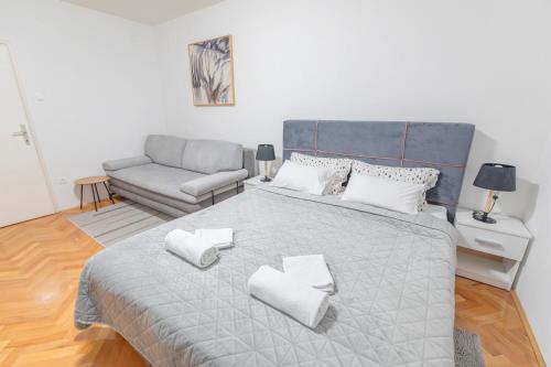 um quarto com uma cama grande e um sofá em Apartman Nora em Čakovec