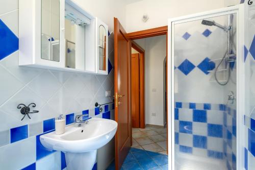 a blue and white bathroom with a sink and a shower at Lazulite - Sardinia Suite in Murta Maria