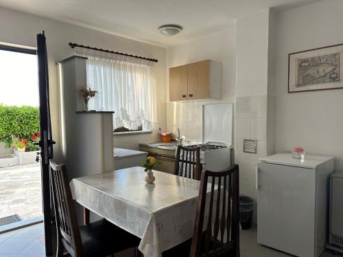 cocina con mesa, sillas y nevera en Apartment Bilić, en Pula