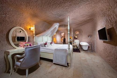 a bedroom with a bed and a desk and a tub at Vigor Cappadocia - Special Class in Uchisar