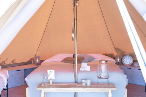 - une chambre avec un lit dans une tente dans l'établissement Little Canvas Escape, à Nes
