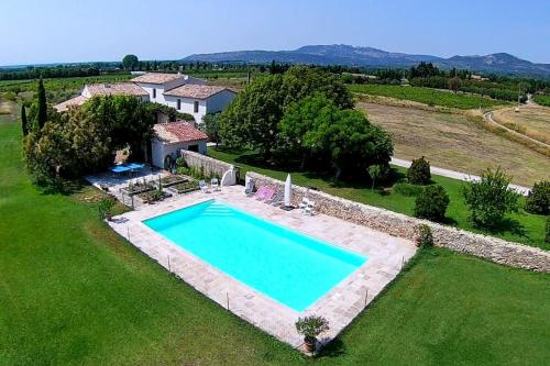 une vue aérienne d'une piscine dans un champ d'herbe dans l'établissement Grand mas provencal tout confort, à Carpentras