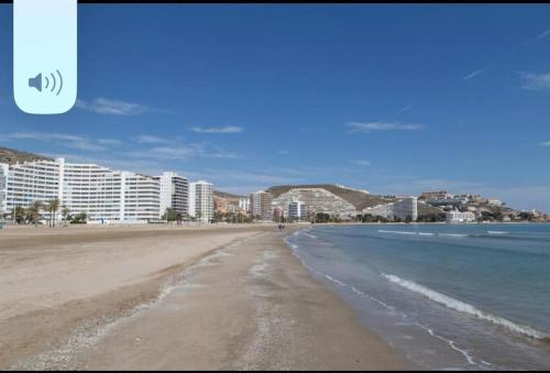 una vista di una spiaggia con edifici sullo sfondo di Acogedor Apartamento Cullera 200 metros playa a Cullera