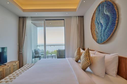 a bedroom with a bed with a view of the ocean at Stone Beach Club in Dhiffushi
