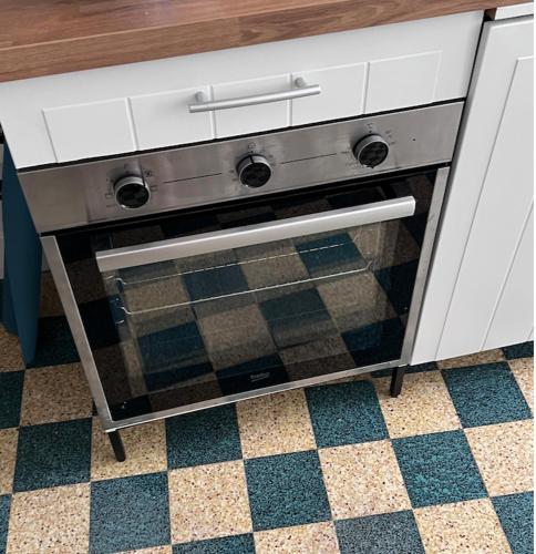 une cuisinière avec une porte vitrée dans une cuisine dans l'établissement Charming Cottage in a typical French Village, à Saint-Christophe-du-Luat