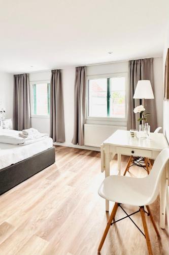 a bedroom with a bed and a desk and a table at Apartments am Wellenreiter in Tating