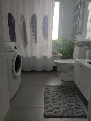 a bathroom with a washing machine and a shower curtain at feel like your own home in Linköping