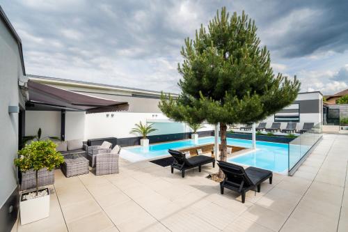 a patio with a tree and a swimming pool at Apartmány Ladná in Ladná
