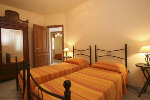 een slaapkamer met 2 bedden met oranje gestreepte lakens bij Lo Scoglio - Goelba in Capoliveri