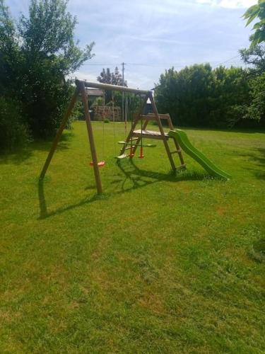 une balançoire dans un champ d'herbe dans l'établissement Bienvenue chez vous !, à Jugeals-Nazareth