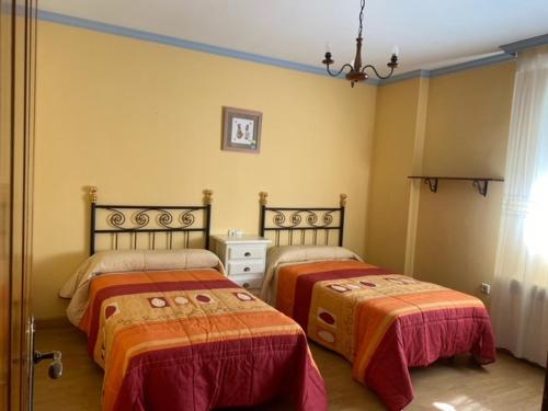 - une chambre avec 2 lits et un lustre dans l'établissement Villa Miriam, à Padul