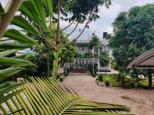 a garden with a palm tree and a building at Luxury 2BR apartment in Usa River