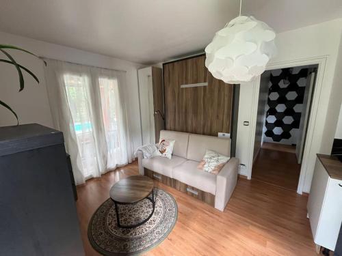 - un salon avec un canapé, une table et un lustre dans l'établissement Studio indépendant avec hammam, à Montpellier