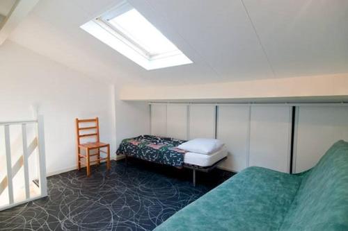 - une chambre avec un lit, une chaise et une lucarne dans l'établissement APPT 3 PCES MEZ 45m2 + TERRASSE 7m2 REF 4007, à Le Castellas