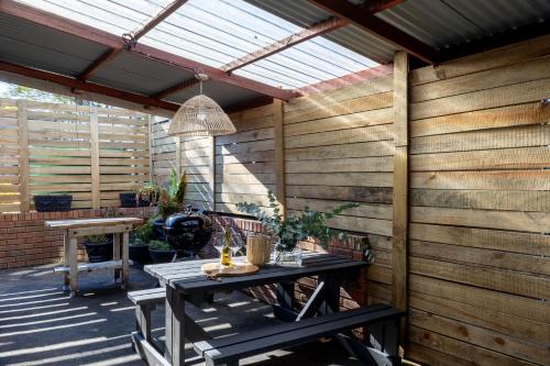 a wooden patio with a table and awning at 24 Bergview Road apartment in Hilton