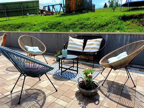 a patio with two chairs and a table and a chair and a couch at Pokoje goscinne u Olguni in Chyrowa