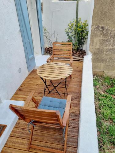 un patio avec une table et des chaises sur une terrasse dans l'établissement Jolie petite maison proche mer, à Valras-Plage