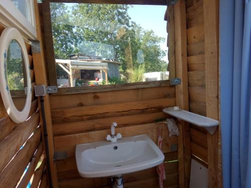 une salle de bain avec un lavabo et une fenêtre dans l'établissement Bivouac, à Le Fay