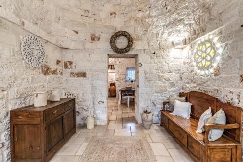 a stone walled room with a bed and a table at Trullo Orto dei Nonni in Ceglie Messapica